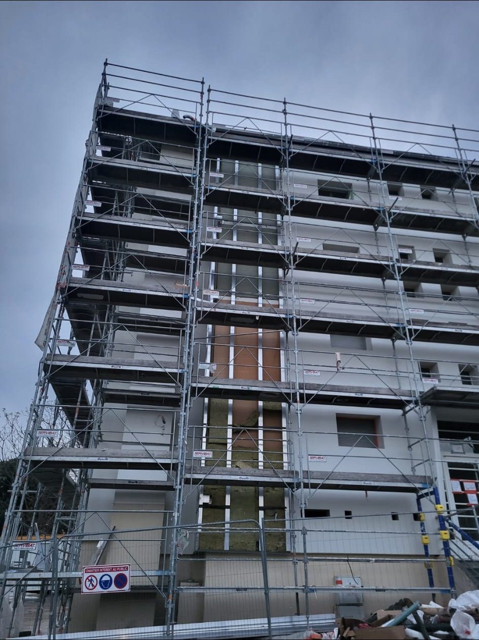 Chantier en cours, ossature et isolant sous échafaudage